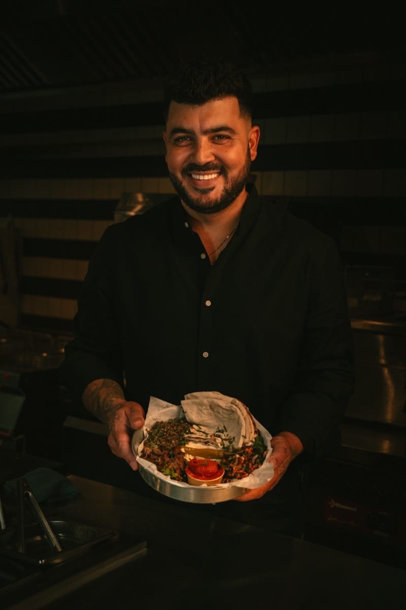 Photo de Georges, souriant, présentant un plat