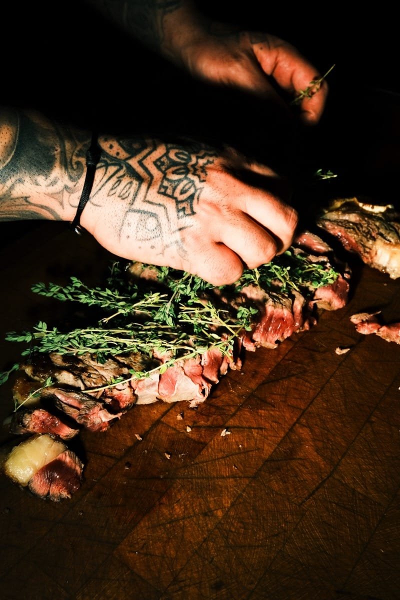 Photo des mains de Georges, cuisinant de la viande