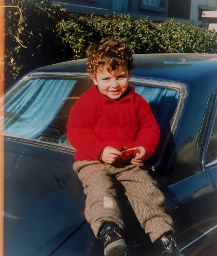 Photo ancienne de Georges enfant assis sur une voiture